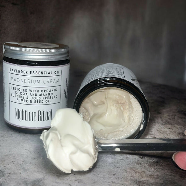 magnesium sleep cream on a metal spoon with jars in background showing the consistency