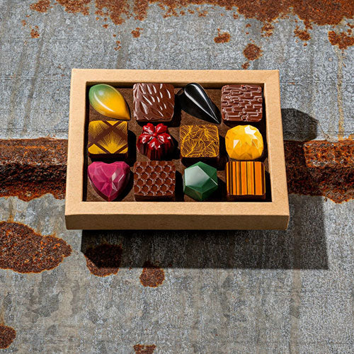 Box of assorted chocolates on a textured metal surface