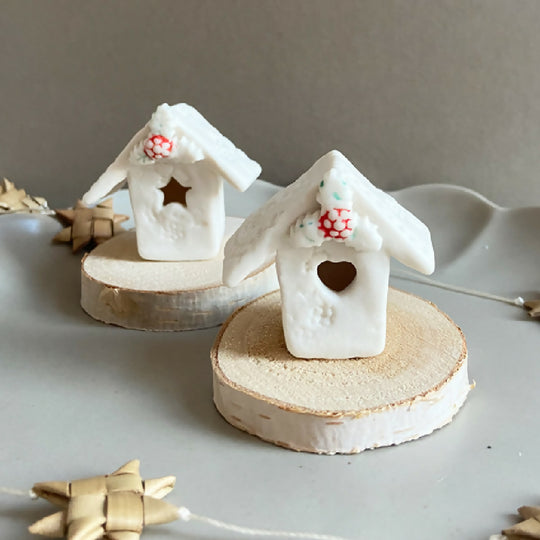 A Mini Christmas House With A Wooden Base
