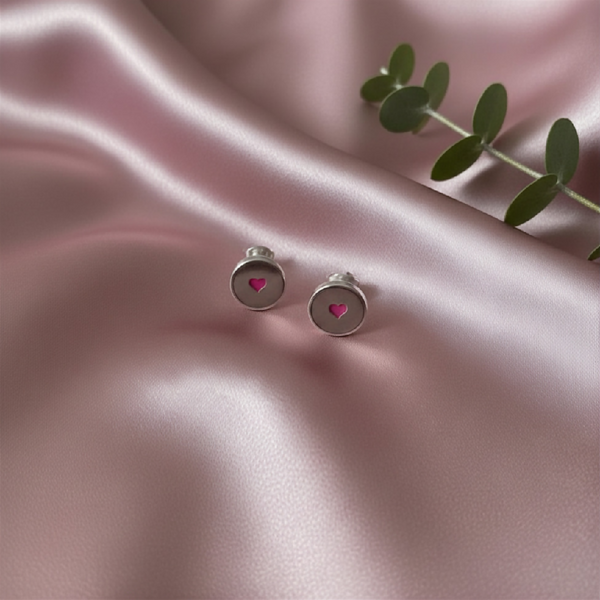 Round silver studs with a pink heart in the centre