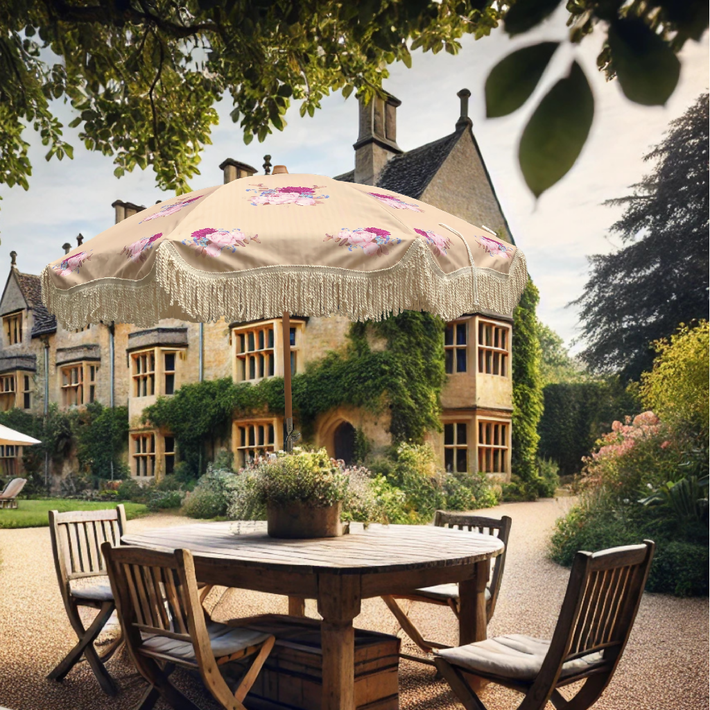 Charming courtyard with the Helena vintage floral parasol featuring cream fringe, shading a rustic wooden dining table, set against a historic ivy-clad manor house for a picturesque outdoor setting