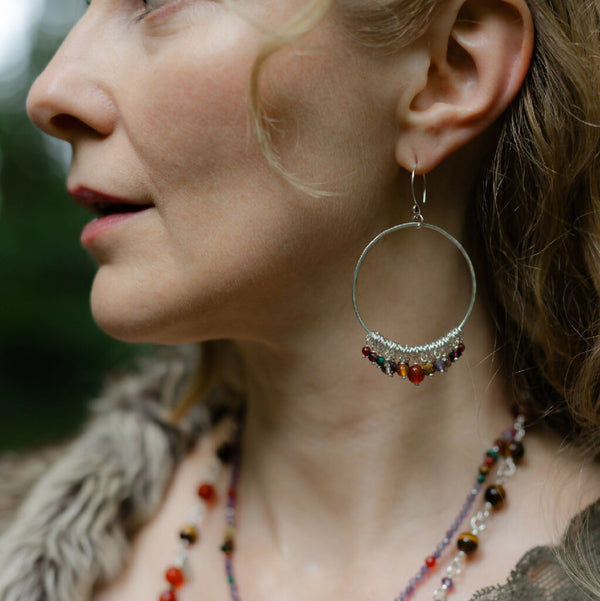 Statement hoop earrings strung with a collection of gemstones in deep russet hues.