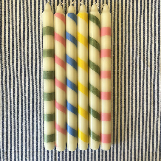 Handpainted ivory candles featuring playful stripes and twists