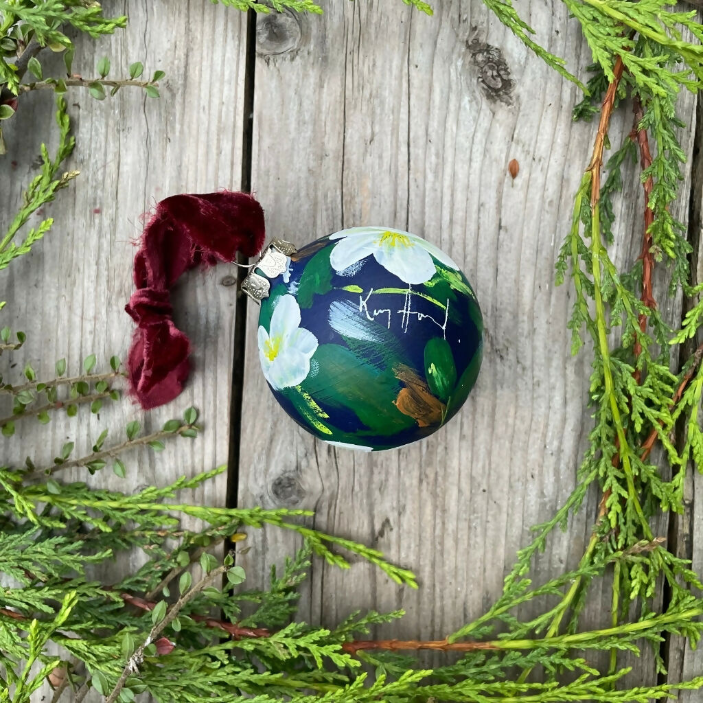 Hand-painted ceramic floral Christmas tree bauble with a deep blue background and white hellebore flowers. Shop more hand-painted Christmas decorations by Kate Godley-Harrod on the Country Living Marketplace.