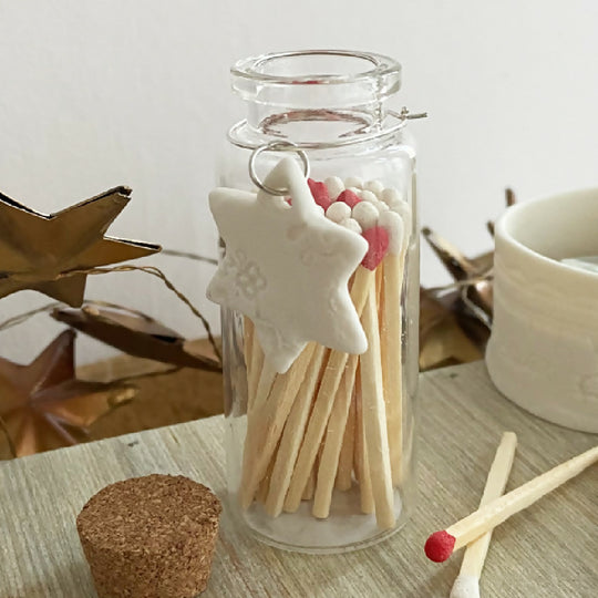 A Bottle Of Red And White Matches With Porcelain Charm