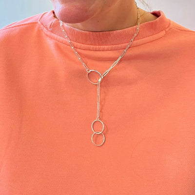 Handmade sterling silver lariat necklace with 3 hoops shown being worn by a model