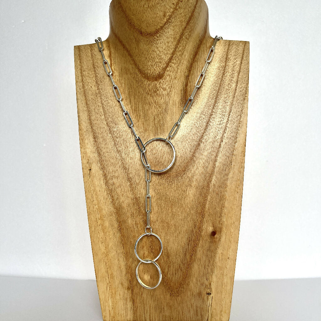 Sterling silver 925 lariat necklace on a chunky chain with 3 hoops displayed on wooden bust against a white background