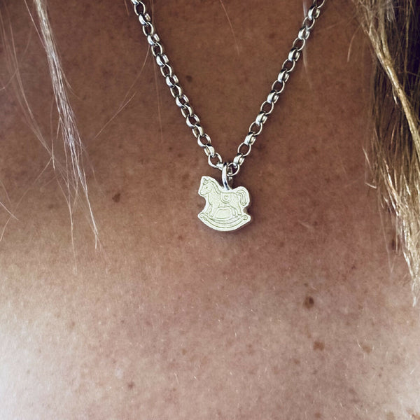 Rocking horse charm necklace worn by a human