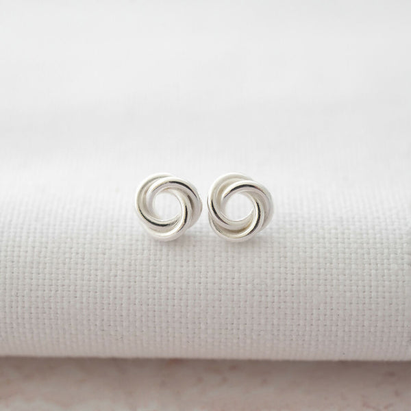 Sterling silver Russian ring stud earrings displayed n white material.