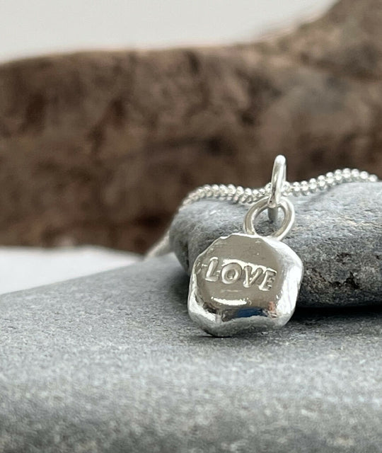 A recycled silver ‘LOVE’ stamped pebble pendant necklace