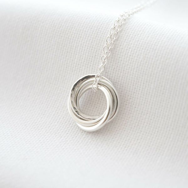 A sterling silver 40th birthday necklace displayed over white material.
