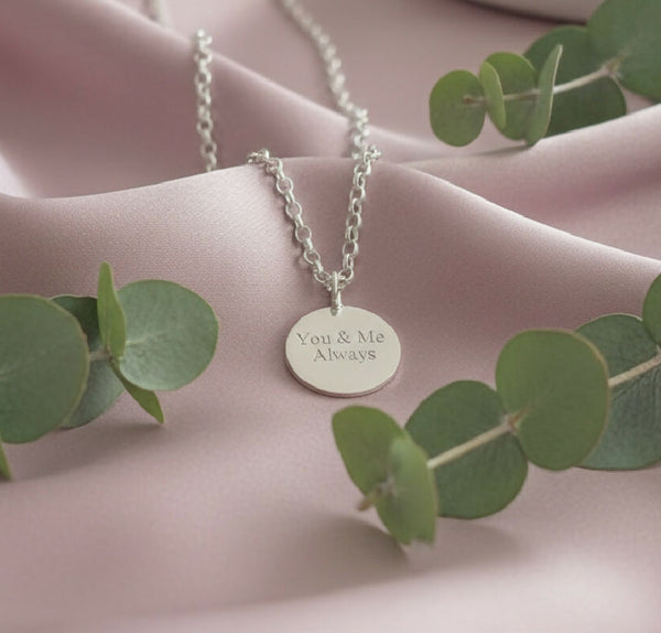 Silver disc with “you and me always” engraved on the front