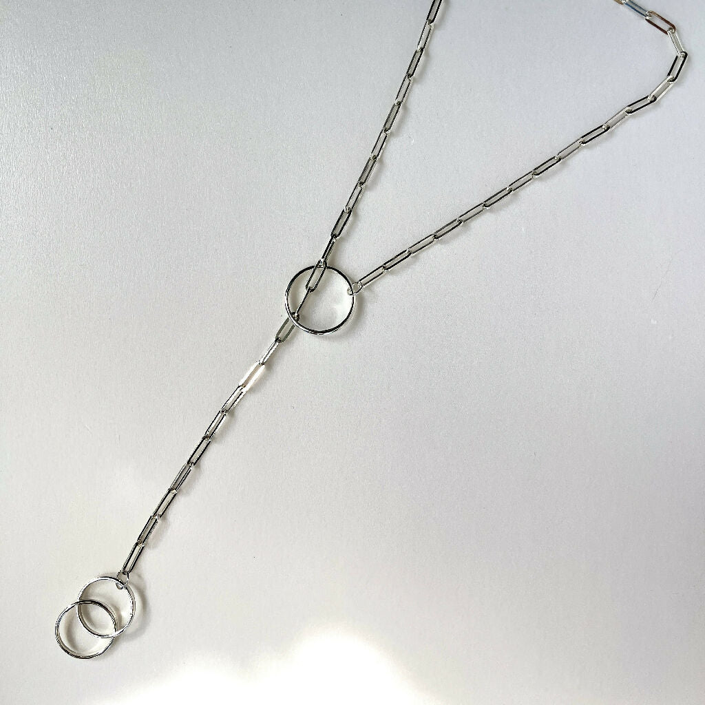 Sterling silver handmade chunky lariat necklace with 3 hoops displayed flat on a while background