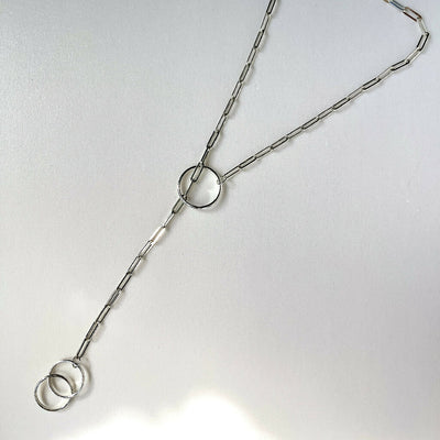 Sterling silver handmade chunky lariat necklace with 3 hoops displayed flat on a while background