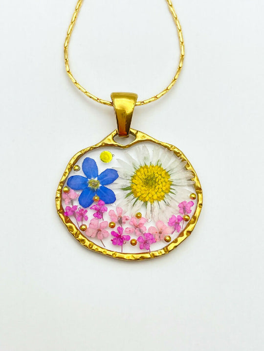 Pendant necklace with daisy and forget me not flowers