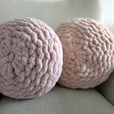 2 pink hand-knit round cushions