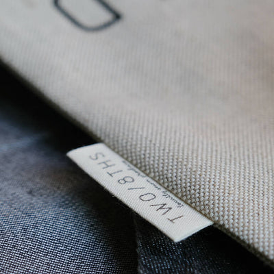 The makers label sewn along the side of a linen produce bag.