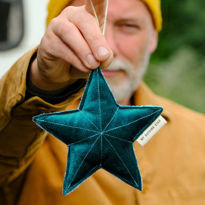 Blue velvet star being held by a man