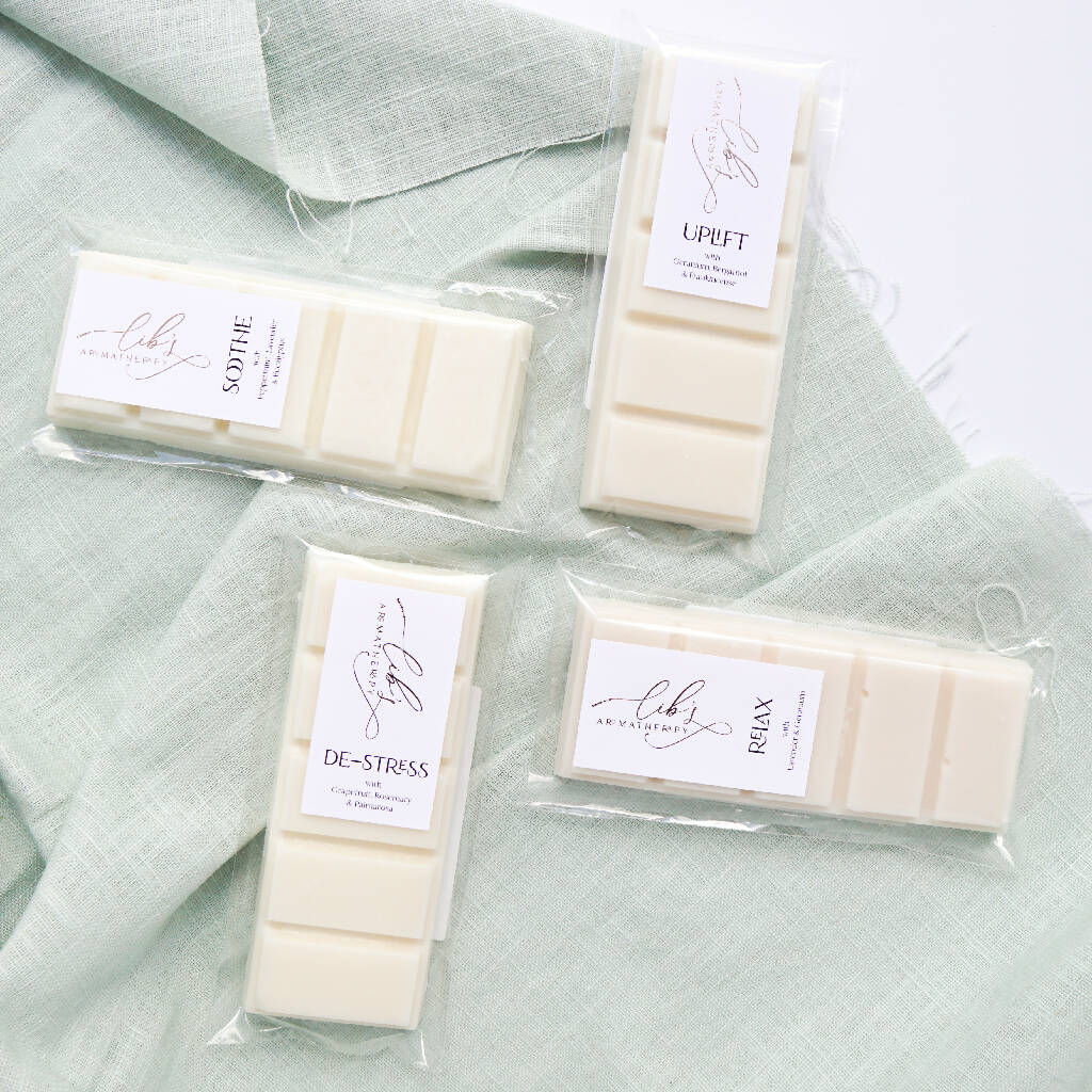 Four soy wax melt bars displayed on a mint green fabric background