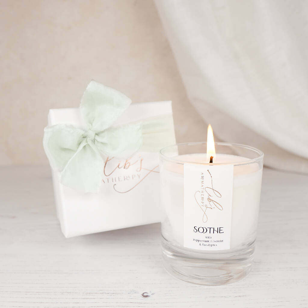 A soothing candle next to a luxury box