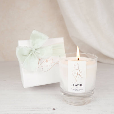 A soothing candle next to a luxury box