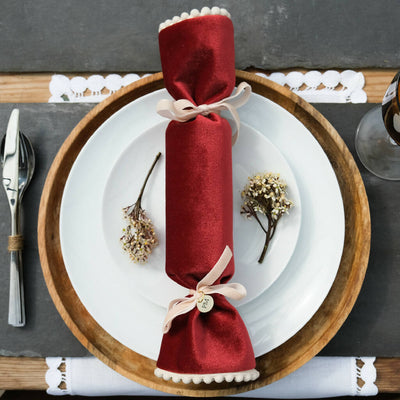 A red velvet christmas cracker set on the dinner table.