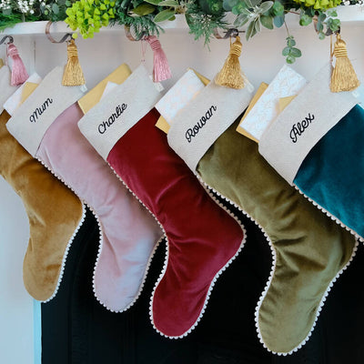 Personalised velvet christmas stockings hung on christmas eve