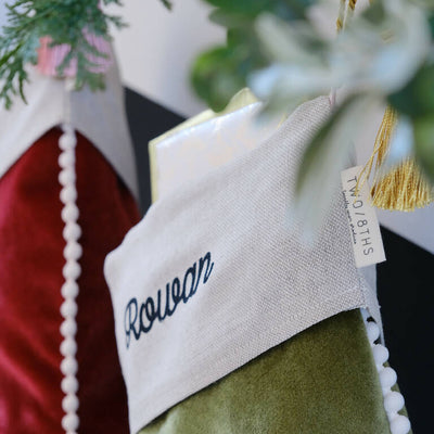 A personalised linen cuff at the top of a christmas stocking