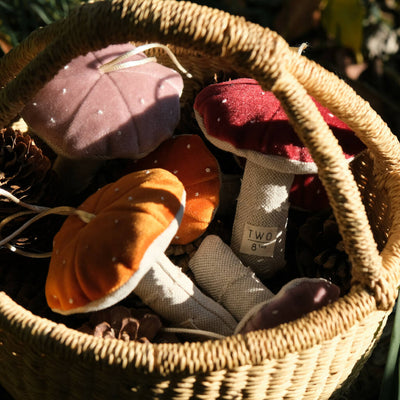 a basket of hand sewn velvet and linen toadstool hanging decorations.