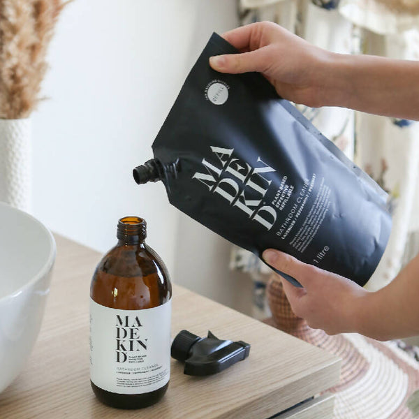 Bathroom cleaner 1 litre pouch being poured into an empty bottle