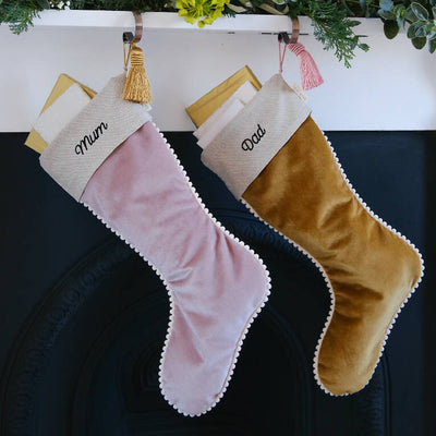Two stockings hung from the mantelpiece - one pink velvet and one hold velvet.