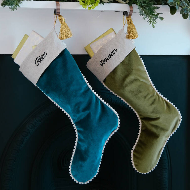 Two velvet personalised christmas stockings hung from the fireplace