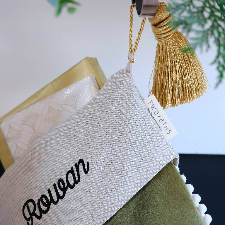 A large gold tassel is used to hang the christmas stocking from.