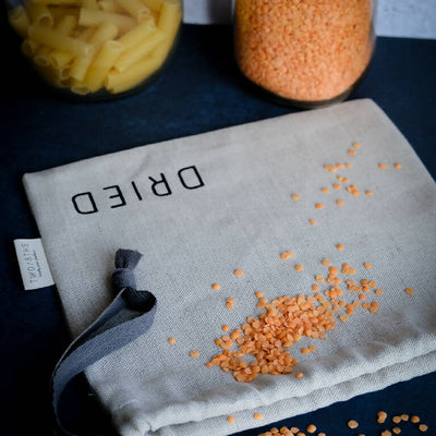 Linen storage bag for dried foods, shown with red lentils and pasta.
